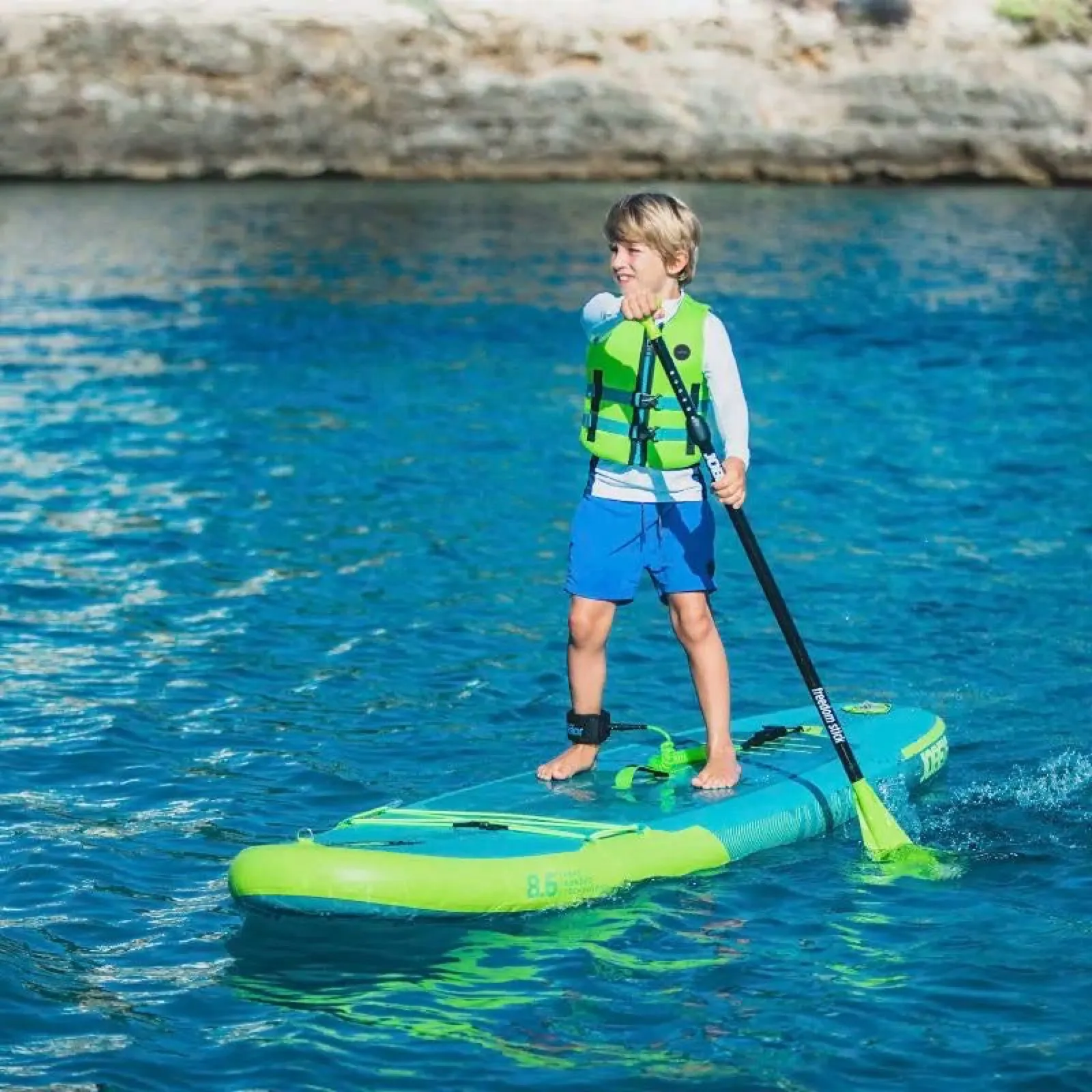 Un bambino in piedi su una tavola da paddle