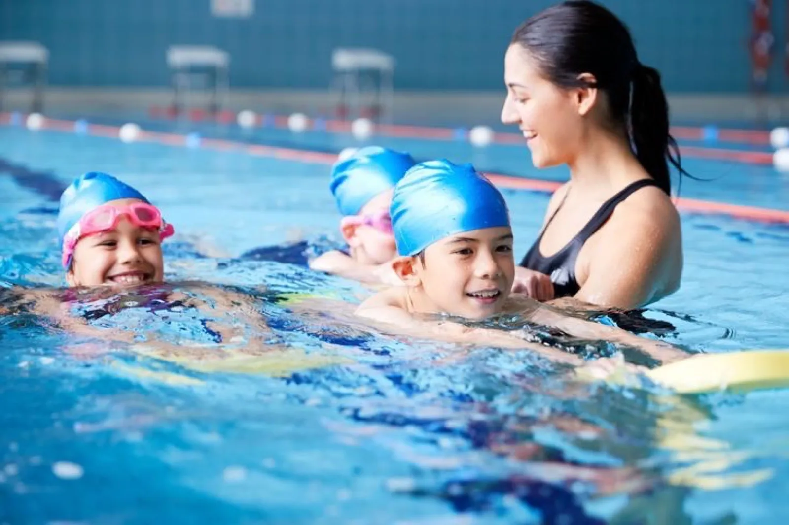 Bambini in piscina con un'istruttrice