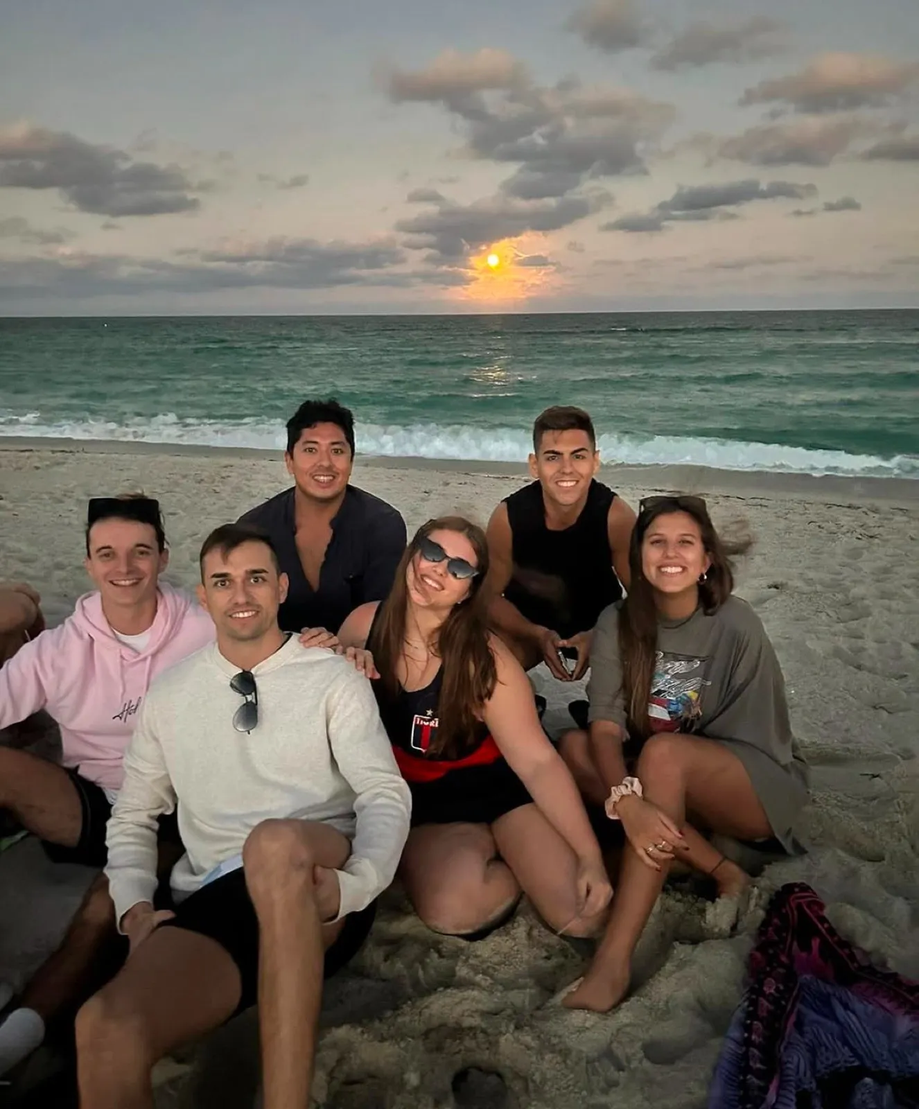 Un gruppo di ragazzi su una spiaggia al tramonto