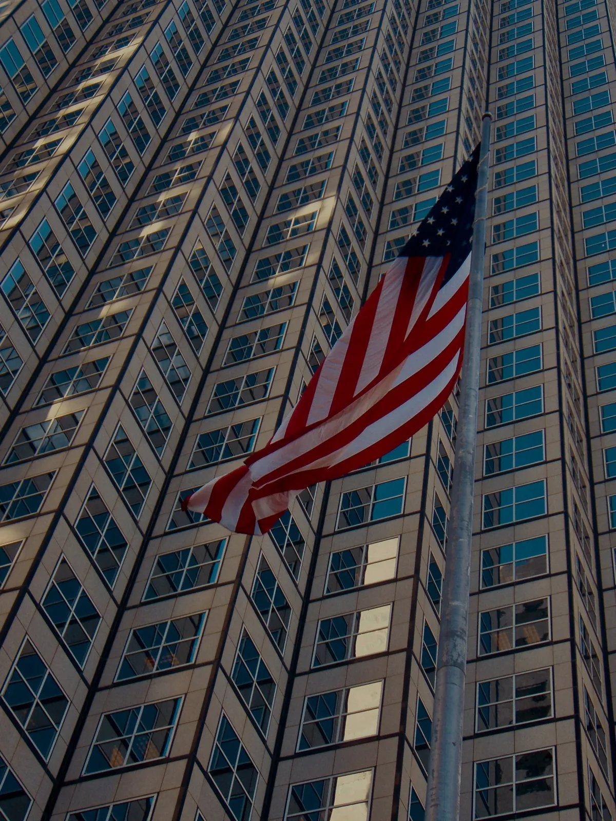 Un grattacielo di vetro con una bandiera americana