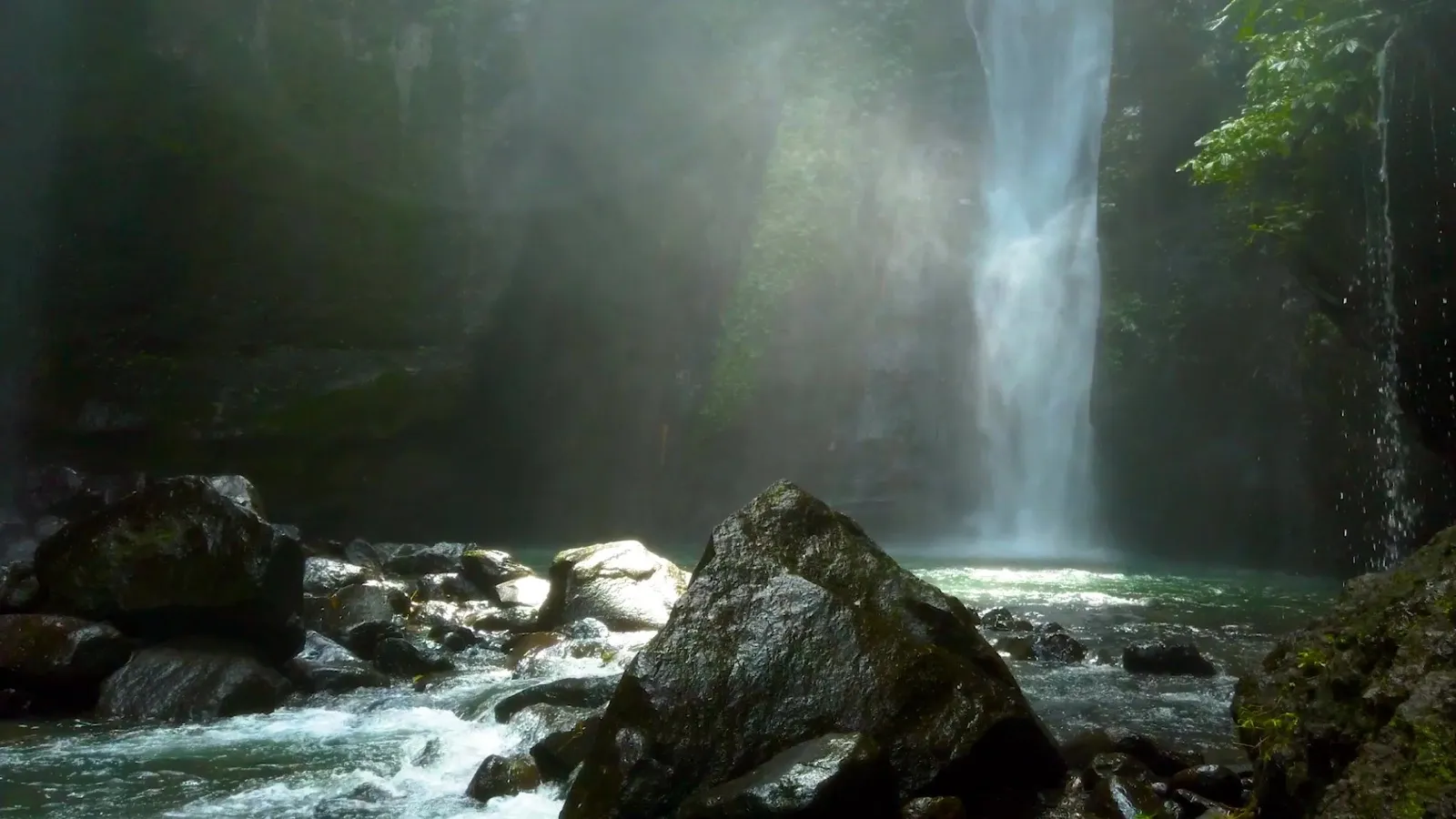 Una cascata che scende su rocce coperte di muschio