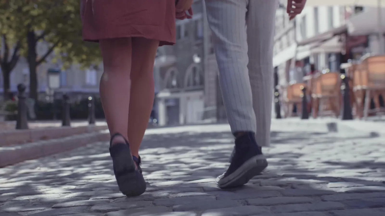 Due persone che camminano lungo una strada, riprese da dietro