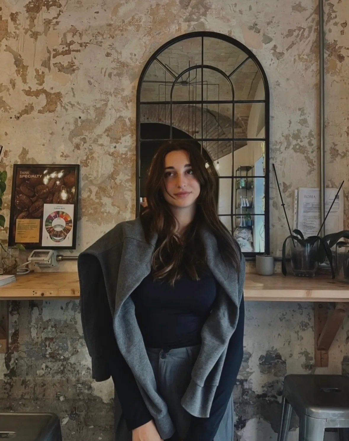 Alessia in un bar, cappotto grigio sulle spalle