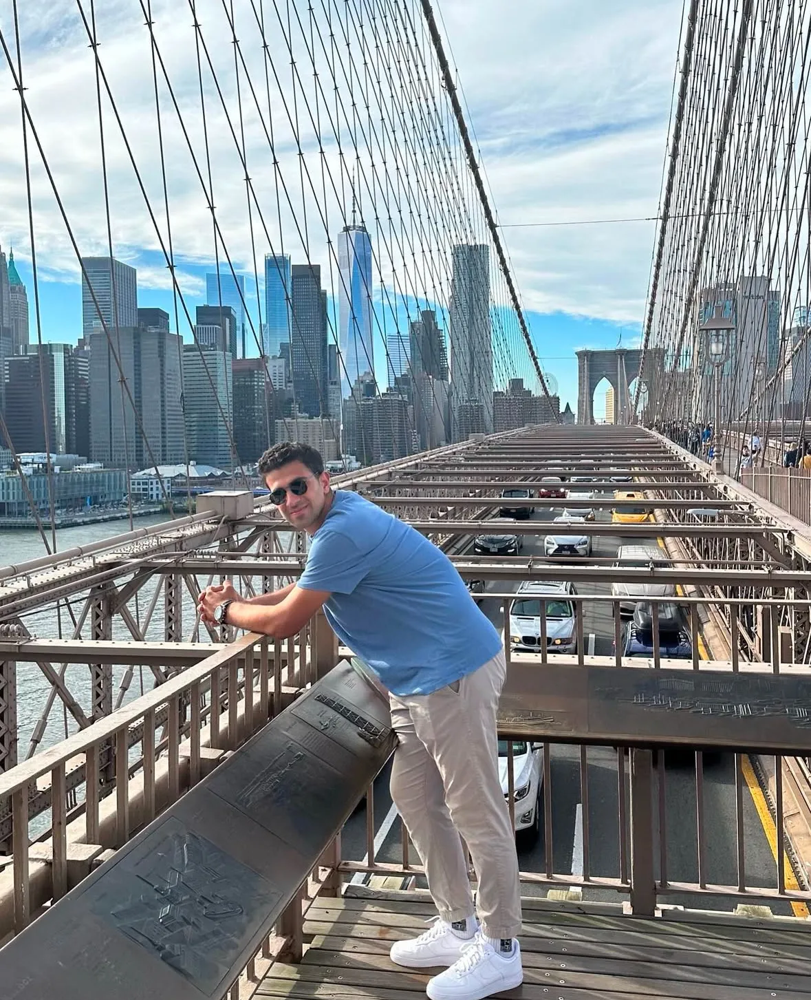 Un ragazzo sul ponte di Brooklyn, lo skyline di Manhattan alle spalle