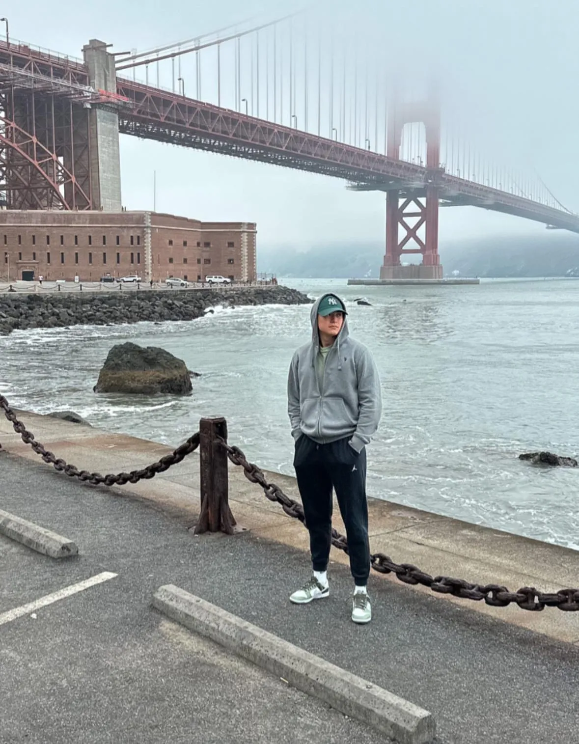 Un ragazzo davanti al Golden Gate nella nebbia