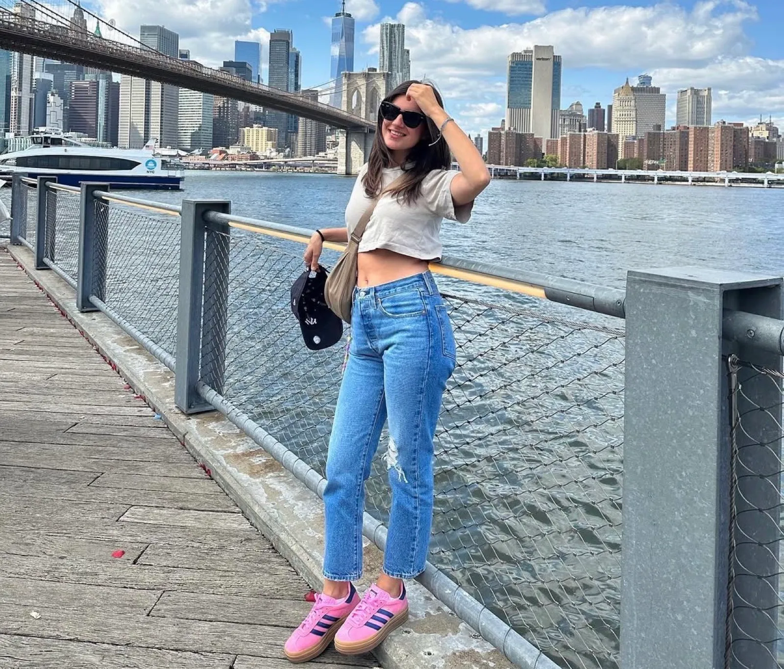 Una ragazza sul lungofiume con lo skyline di Manhattan alle spalle